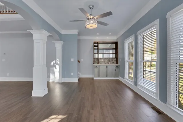 a view of a livingroom with a chandelier wooden floor and a fireplace