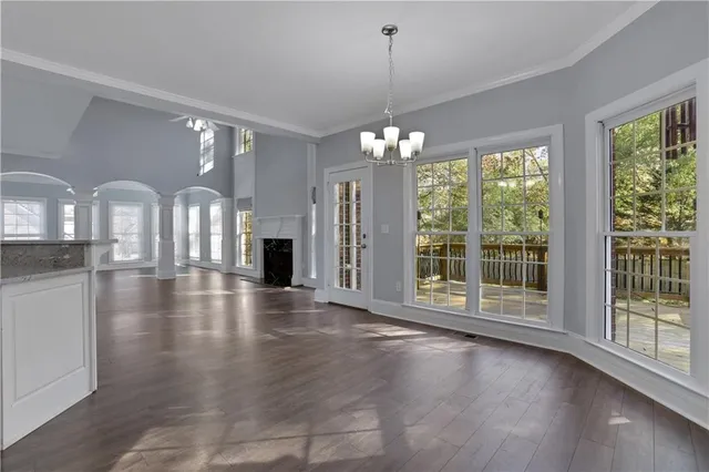 a kitchen with stainless steel appliances granite countertop a stove top oven a sink dishwasher and white cabinets with wooden floor