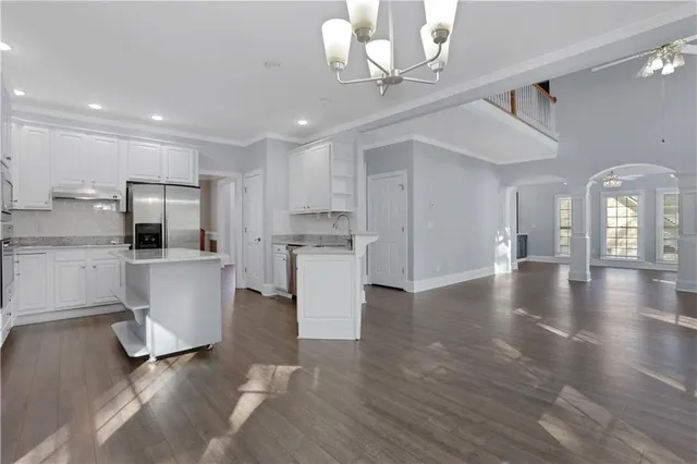 a kitchen with granite countertop white cabinets and black stainless steel appliances