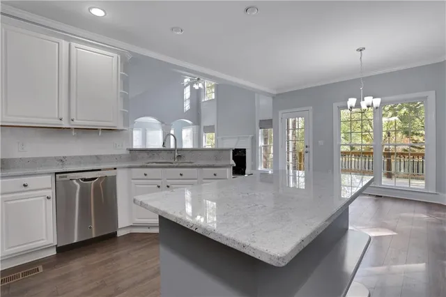 an empty room with a chandelier fan and windows