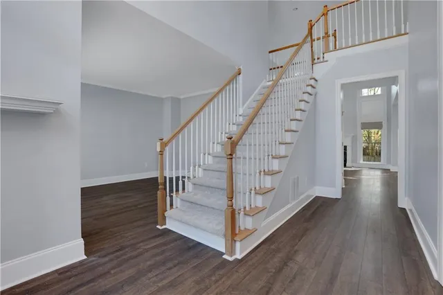 an empty room with wooden floor fireplace and windows