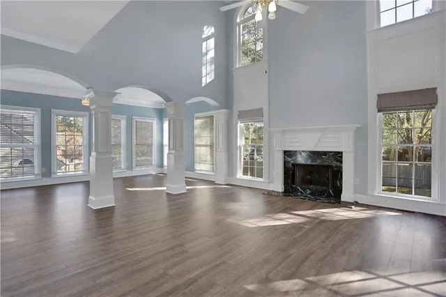 a view of an empty room with a window and wooden floor