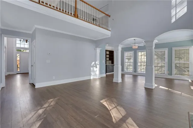 a view of an empty room with kitchen and a window