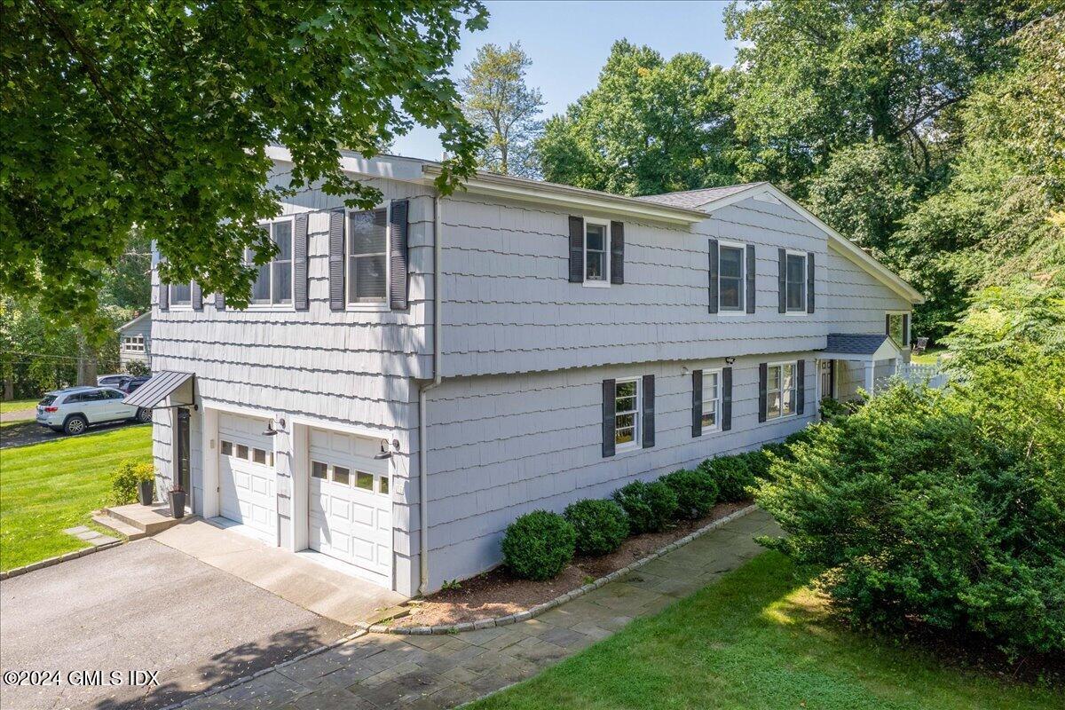70 Gregory Road Cos Cob, CT 06807 - Photo 2 of 39 a view of a white house next to a yard with big trees