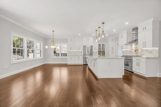 a view of a kitchen with kitchen island a sink wooden floor and counter top space