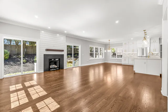 a view of empty room with wooden floor and fireplace
