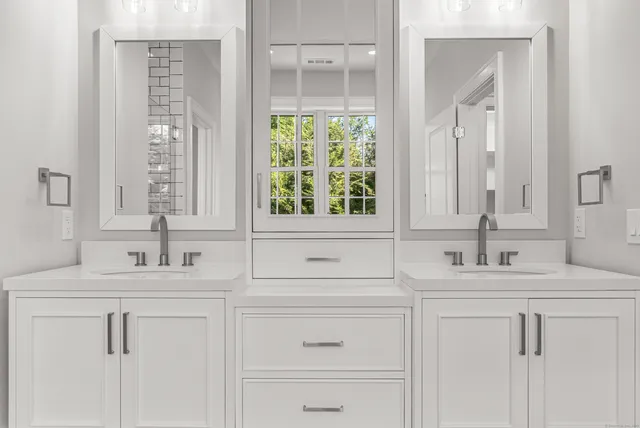 a bathroom with double sink and a mirror