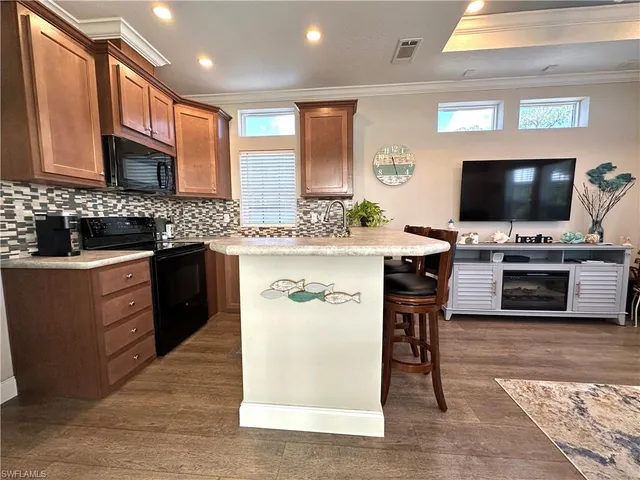 a kitchen with stainless steel appliances kitchen island granite countertop a sink and a stove