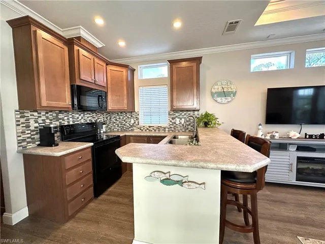 a kitchen with stainless steel appliances wooden cabinets granite counter tops a stove a sink and a refrigerator