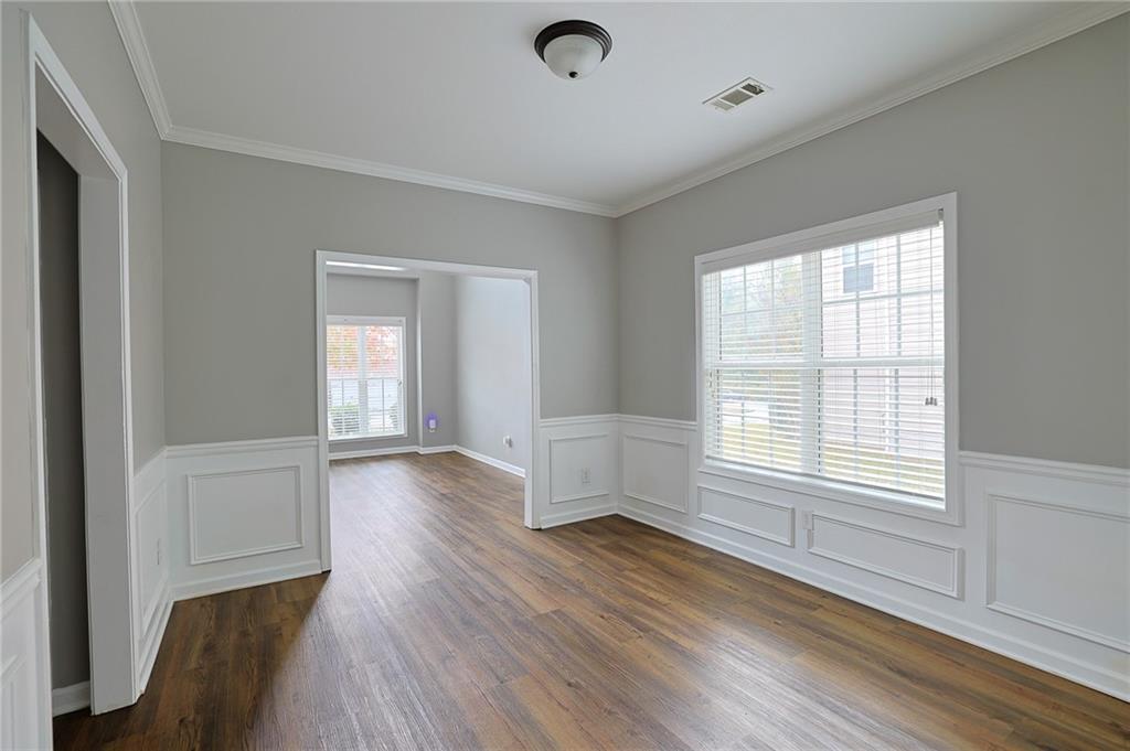 910 Lakeside Court Loganville, GA 30052 - Photo 13 of 57 an empty room with wooden floor and windows