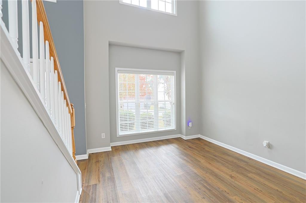 910 Lakeside Court Loganville, GA 30052 - Photo 15 of 57 an empty room with wooden floor and windows