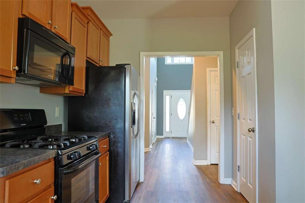 910 Lakeside Court Loganville, GA 30052 - Photo 20 of 57 a kitchen with wooden floors and stainless steel appliances