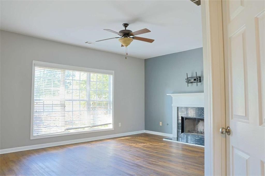 910 Lakeside Court Loganville, GA 30052 - Photo 21 of 57 a view of an empty room with wooden floor and a window