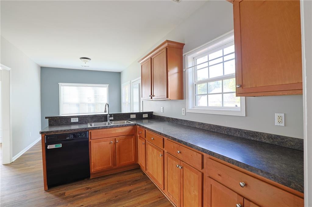 910 Lakeside Court Loganville, GA 30052 - Photo 25 of 57 a kitchen with granite countertop stainless steel appliances a sink window and cabinets