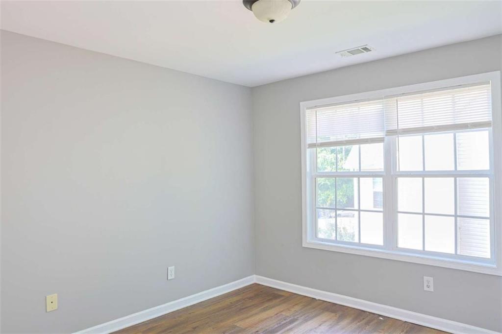 910 Lakeside Court Loganville, GA 30052 - Photo 31 of 57 an empty room with wooden floor and windows