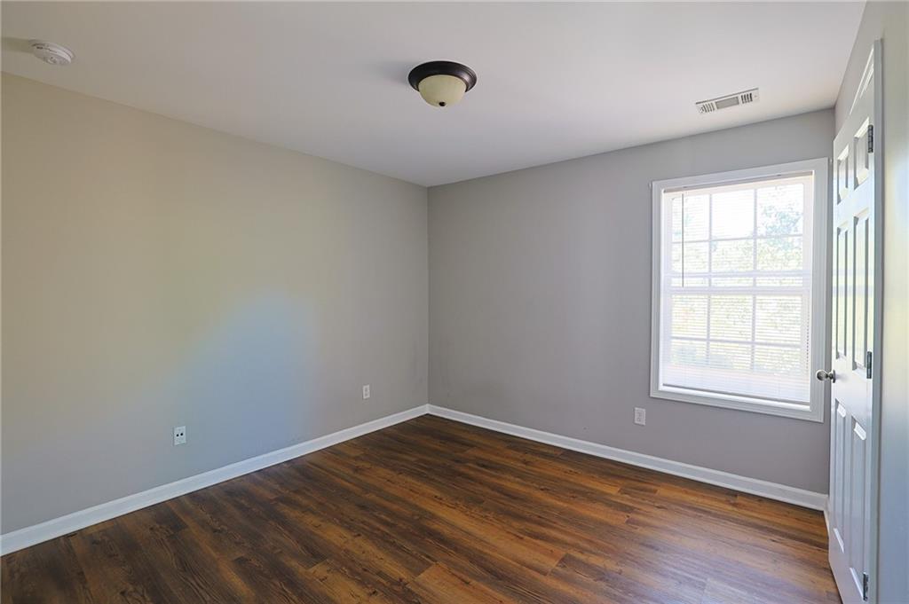 910 Lakeside Court Loganville, GA 30052 - Photo 47 of 57 an empty room with wooden floor and windows