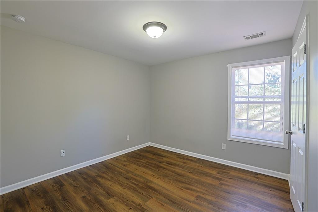 910 Lakeside Court Loganville, GA 30052 - Photo 48 of 57 an empty room with wooden floor and windows