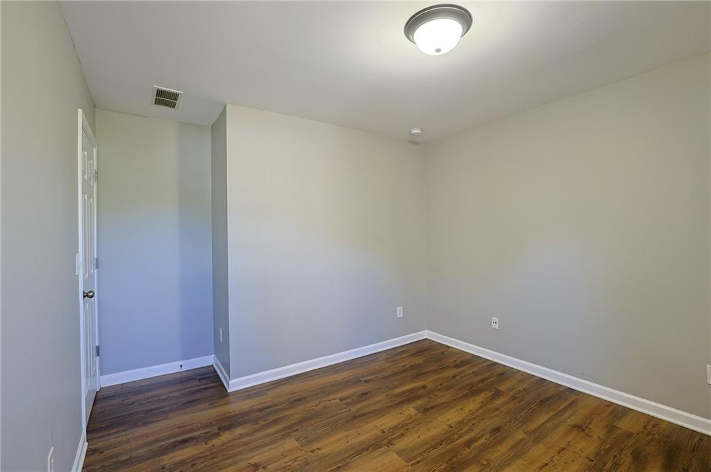 910 Lakeside Court Loganville, GA 30052 - Photo 49 of 57 an empty room with wooden floor and windows