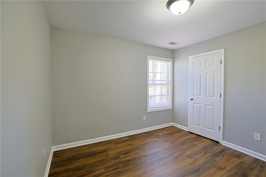 910 Lakeside Court Loganville, GA 30052 - Photo 51 of 57 an empty room with wooden floor and windows