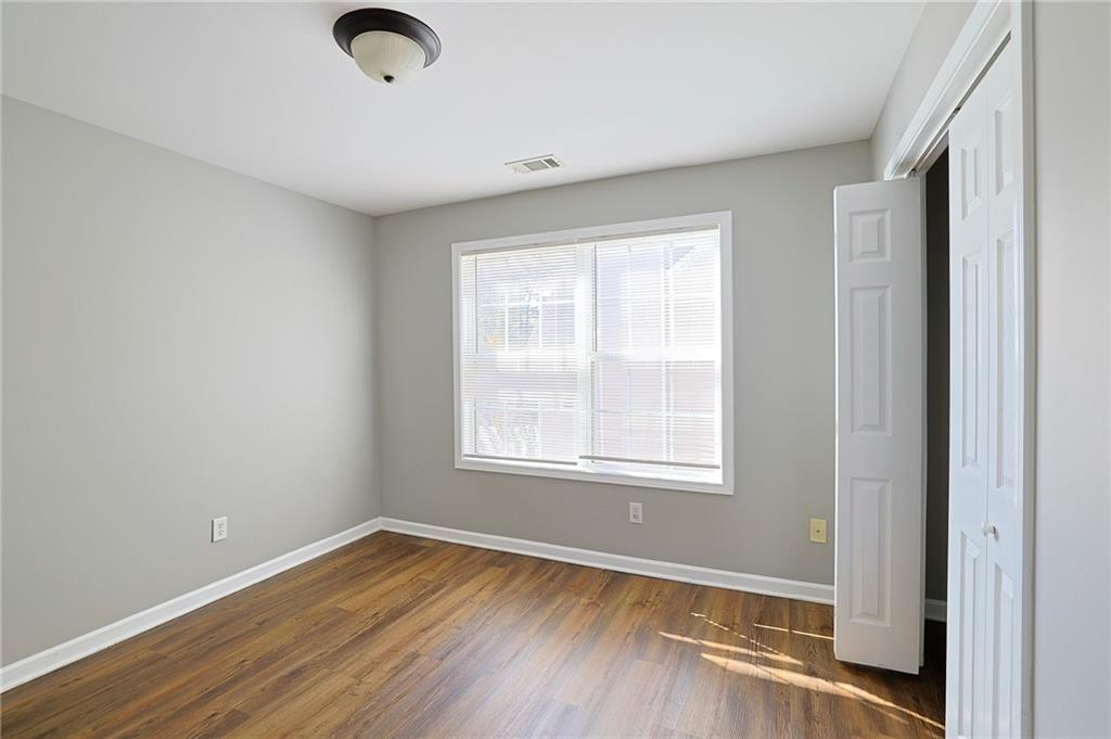 910 Lakeside Court Loganville, GA 30052 - Photo 52 of 57 an empty room with wooden floor and windows