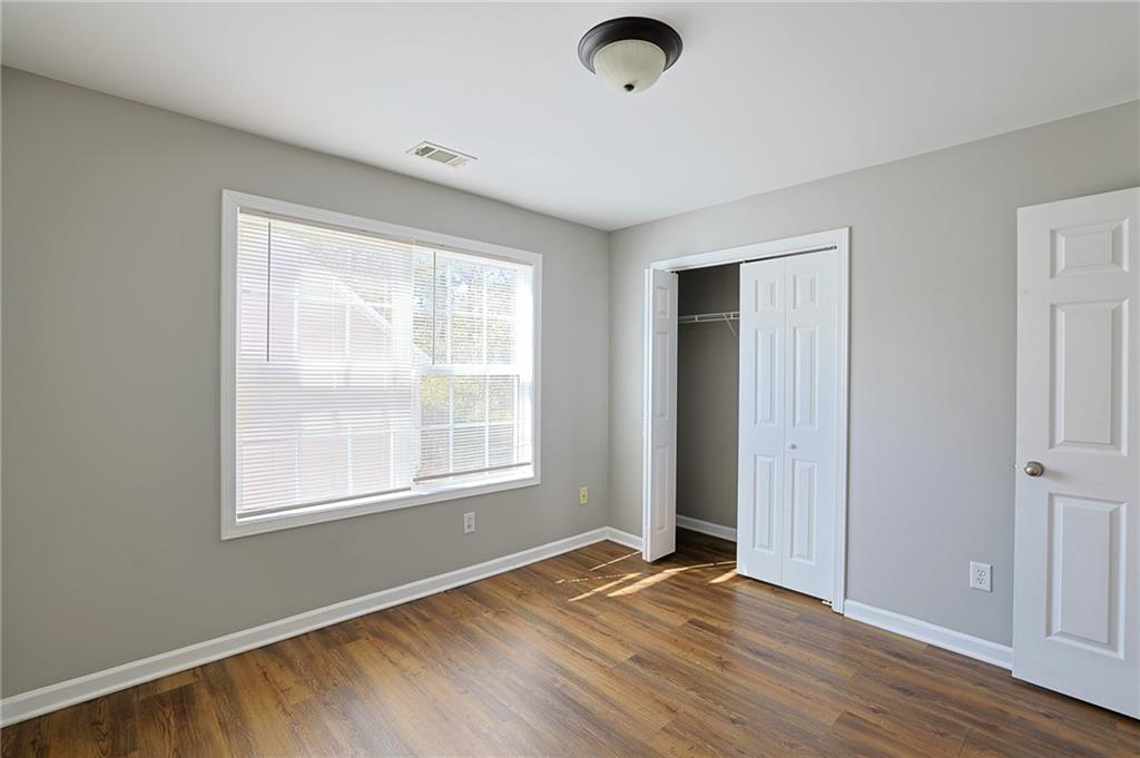 910 Lakeside Court Loganville, GA 30052 - Photo 53 of 57 an empty room with wooden floor and windows