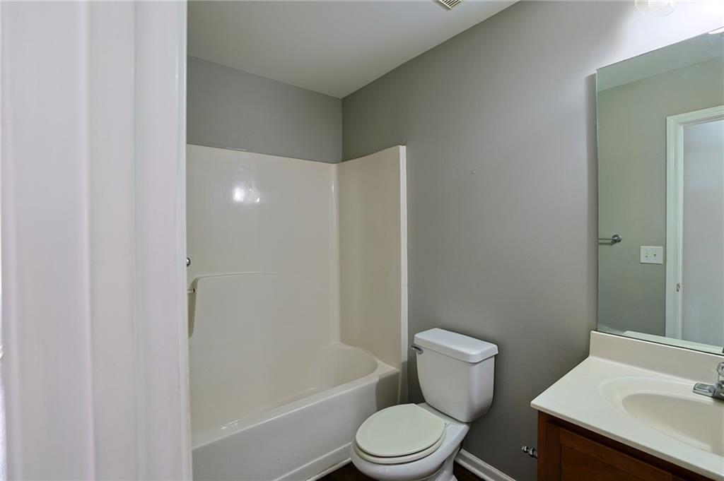 910 Lakeside Court Loganville, GA 30052 - Photo 56 of 57 a white toilet sitting next to a bathroom sink and tub