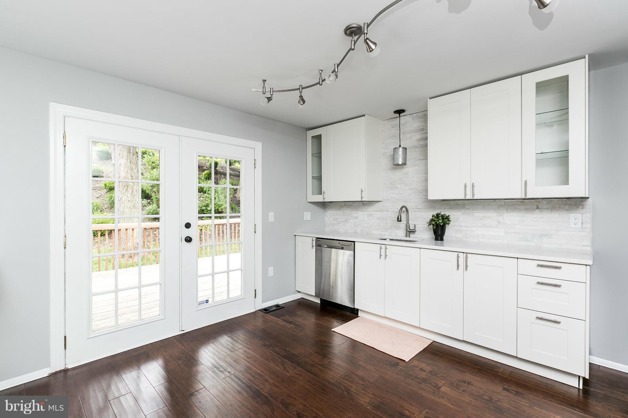 4527 Tapscott Road Baltimore, MD 21208 - Photo 11 of 30 a kitchen with stainless steel appliances white cabinets and wooden floors