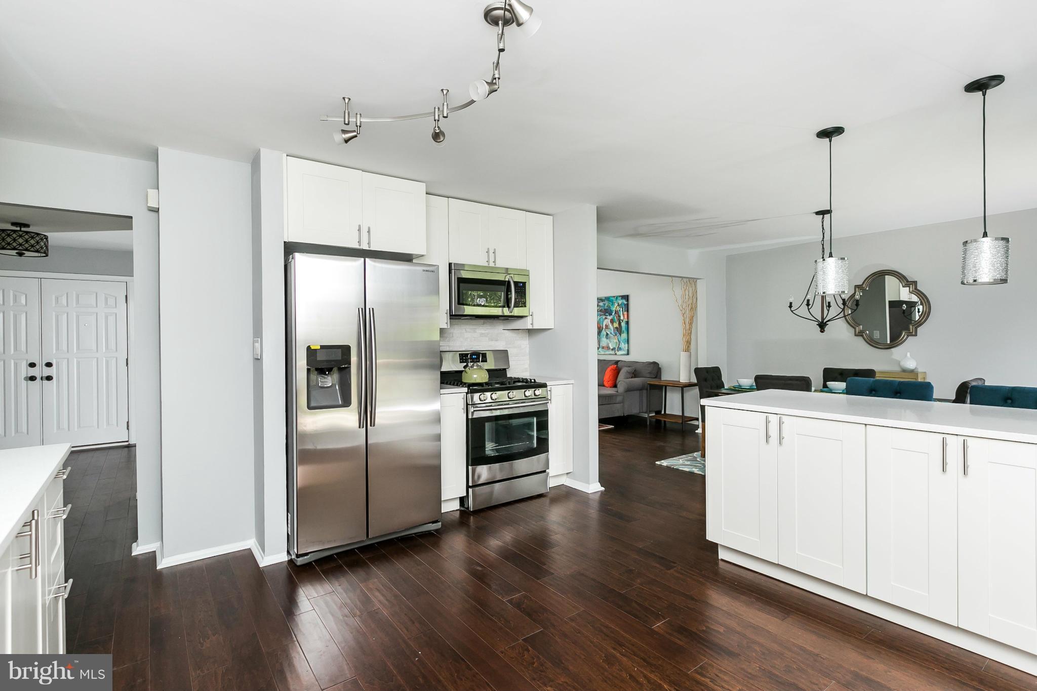 4527 Tapscott Road Baltimore, MD 21208 - Photo 13 of 30 a kitchen with a refrigerator and white cabinets