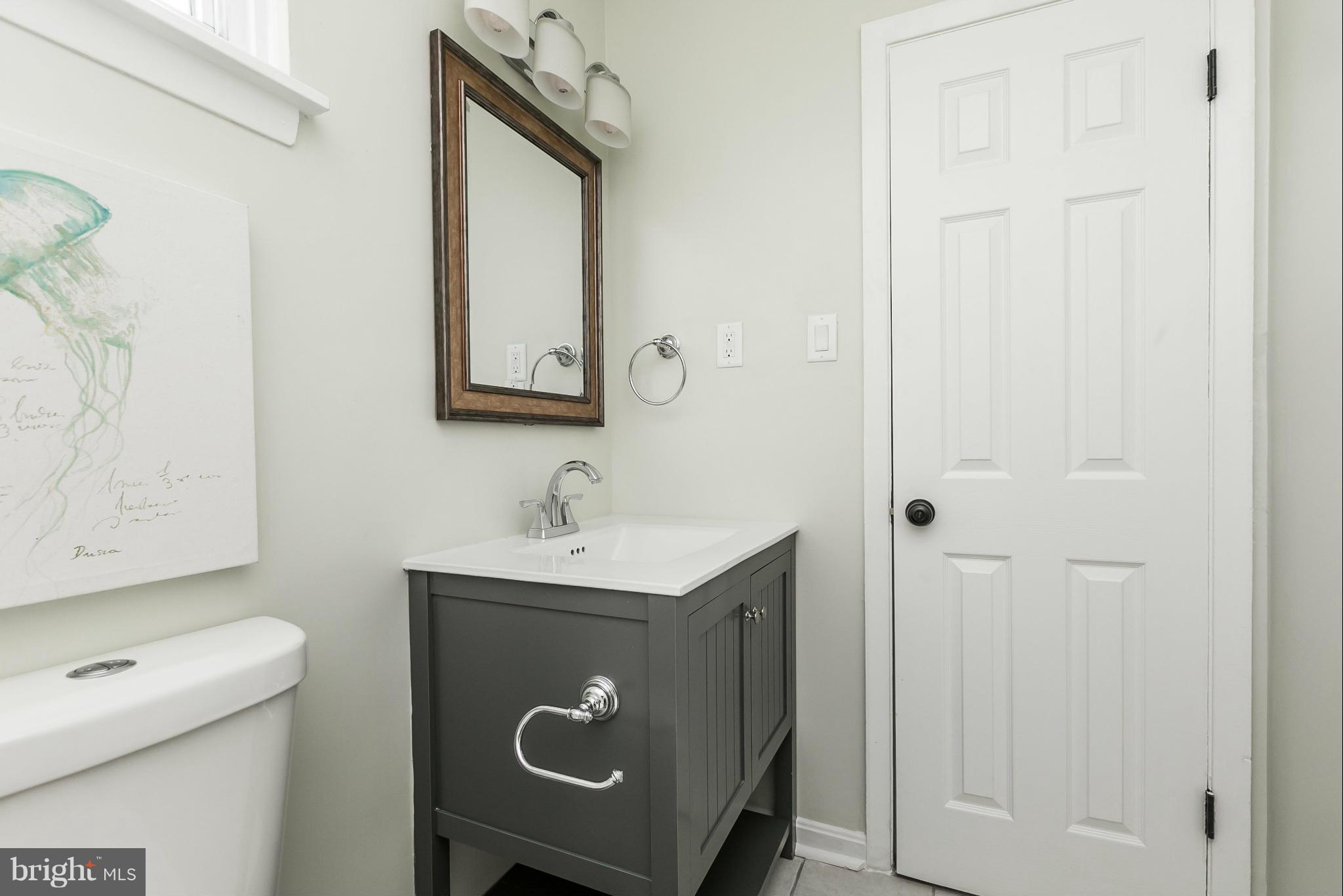 4527 Tapscott Road Baltimore, MD 21208 - Photo 17 of 30 a bathroom with a sink a toilet and mirror