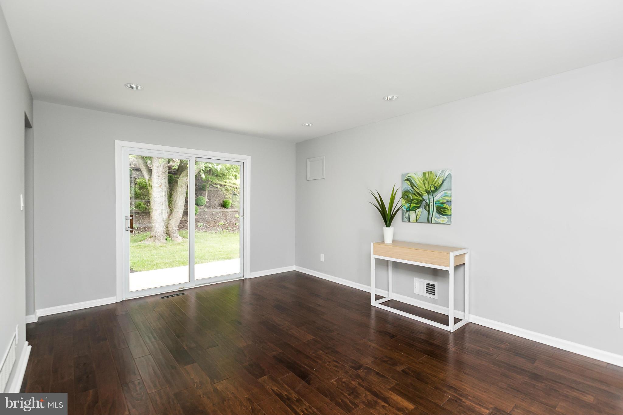 4527 Tapscott Road Baltimore, MD 21208 - Photo 4 of 30 a view of an empty room with a window and wooden floor