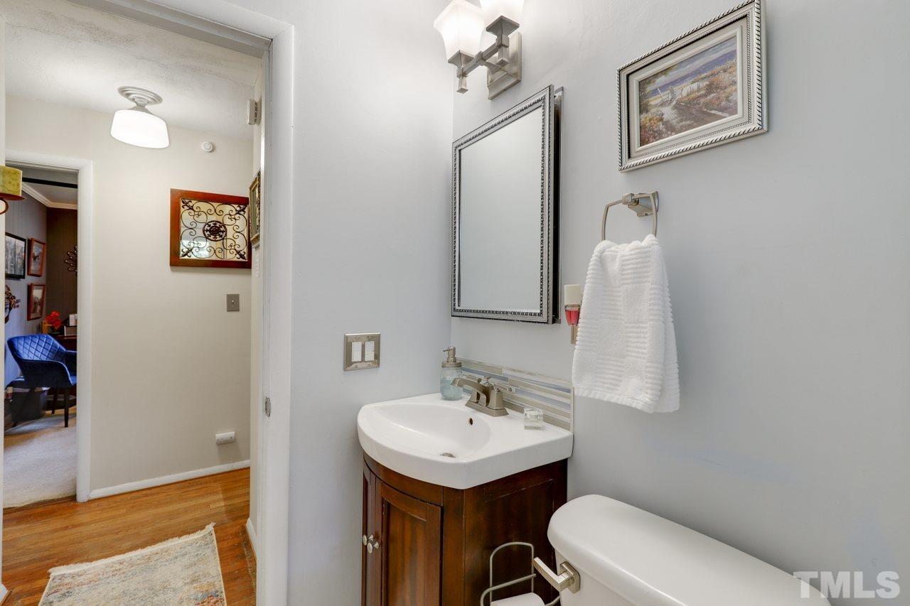 1306 Valley Road Garner, NC 27529 - Photo 13 of 18 a bathroom with a toilet a sink and mirror