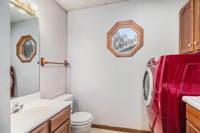 a bathroom with a toilet a sink and a mirror