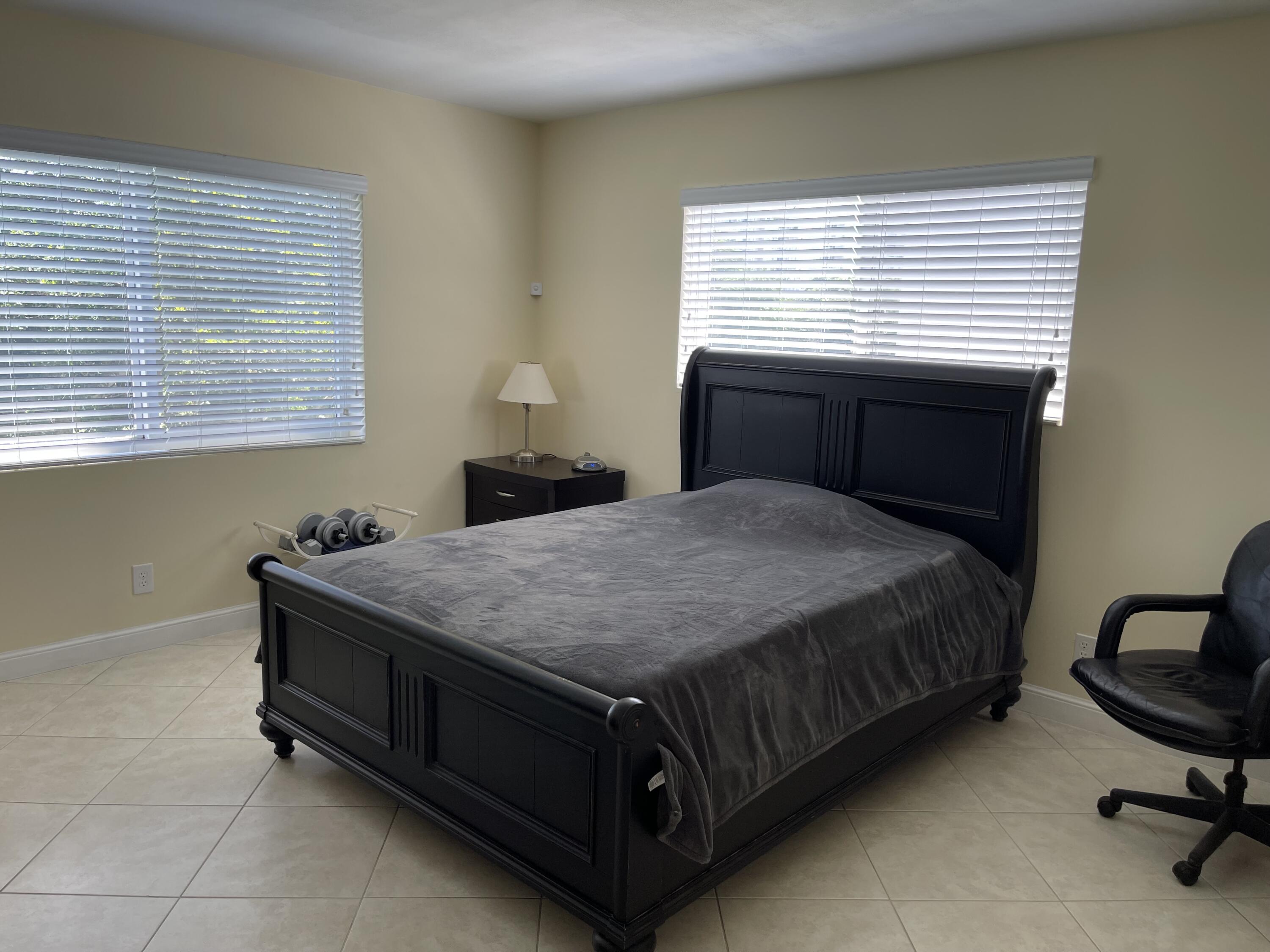 300 East Royal Palm Road, Unit 42B Boca Raton, FL 33432 - Photo 33 of 51 a bed sitting in a bedroom next to a window