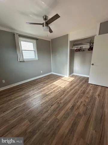 a view of a big room with wooden floor closet and windows
