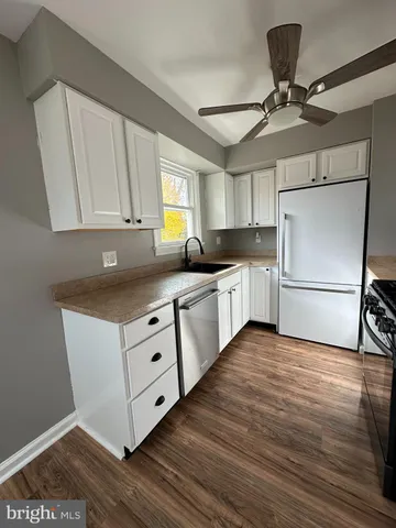 a kitchen with granite countertop a sink appliances and cabinets