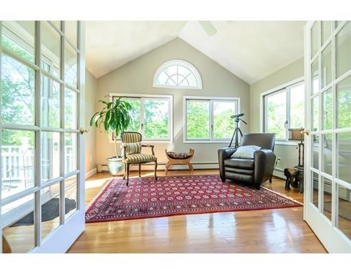 7 Snowberry Road Andover, MA 01810 - Photo 14 of 30 a living room with a rug floor to ceiling windows and a dining table with garden view