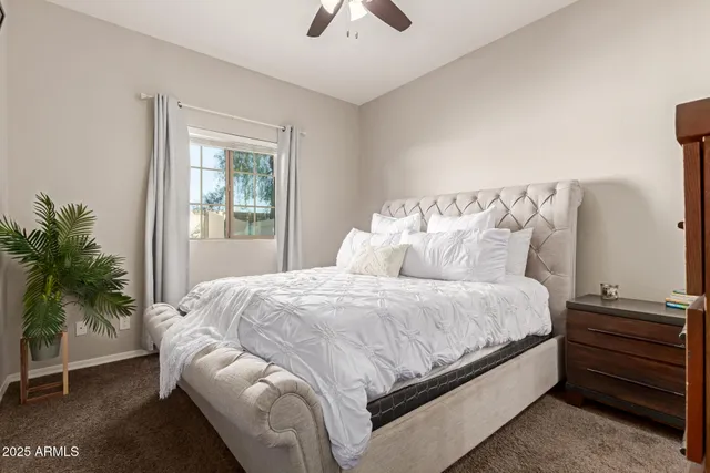 a large bed sitting in a bedroom next to a window and a chandelier