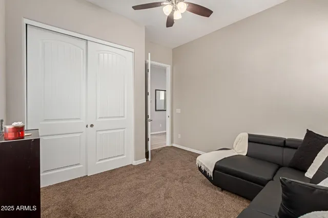a living room with furniture and a ceiling fan
