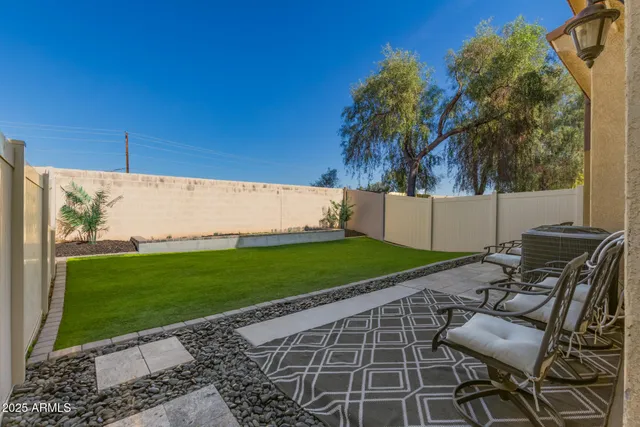 a view of a backyard with chair and potted plants