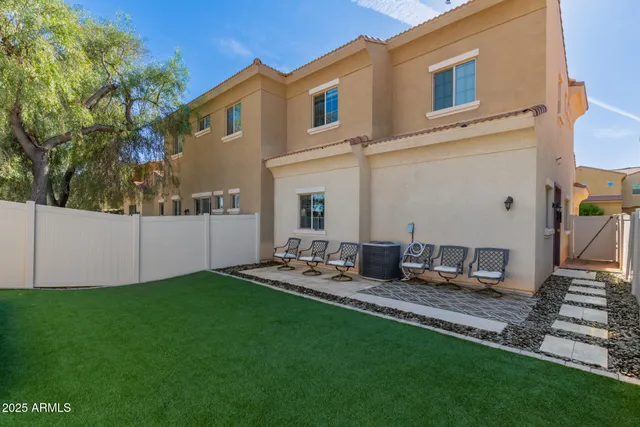 a backyard of a house with table and chairs
