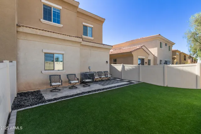 a view of a backyard with table and chairs and wooden fence