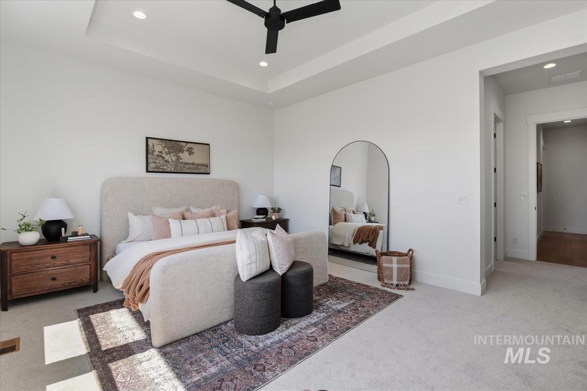 7615 Brown Way Eagle, ID 83714 - Photo 25 of 43 Expansive bedroom featuring tray ceilings with recessed lighting and a ceiling fan