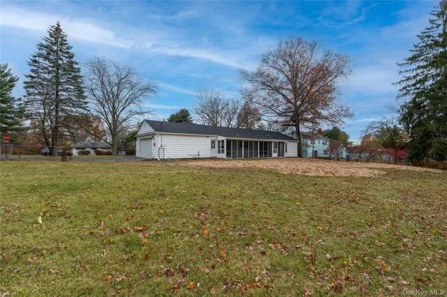 a front view of house with yard and trees around