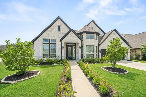 a front view of a house with yard and green space