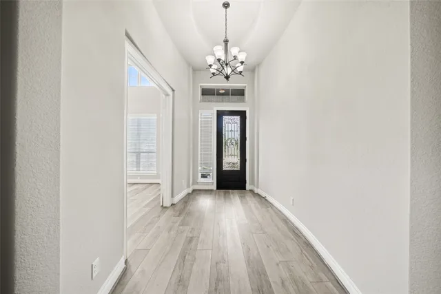 a view of a chandelier in big room with wooden floor