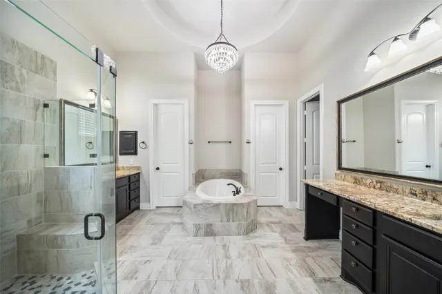 a bathroom with a sink a toilet a mirror and shower