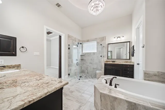 a bathroom with a granite countertop sink a mirror and a bathtub