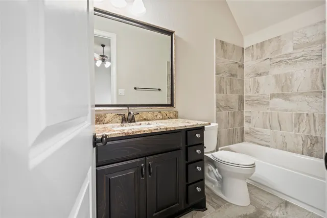 a bathroom with a granite countertop sink toilet and shower