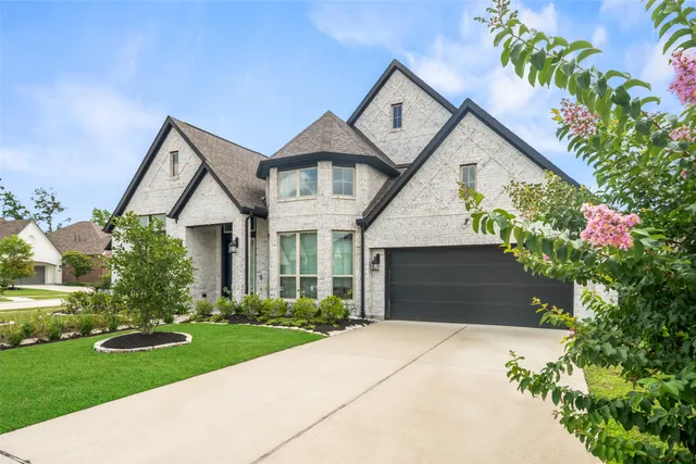 a front view of a house with a yard and trees