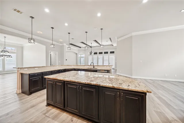 a kitchen with stainless steel appliances granite countertop a sink a stove and a wooden floors